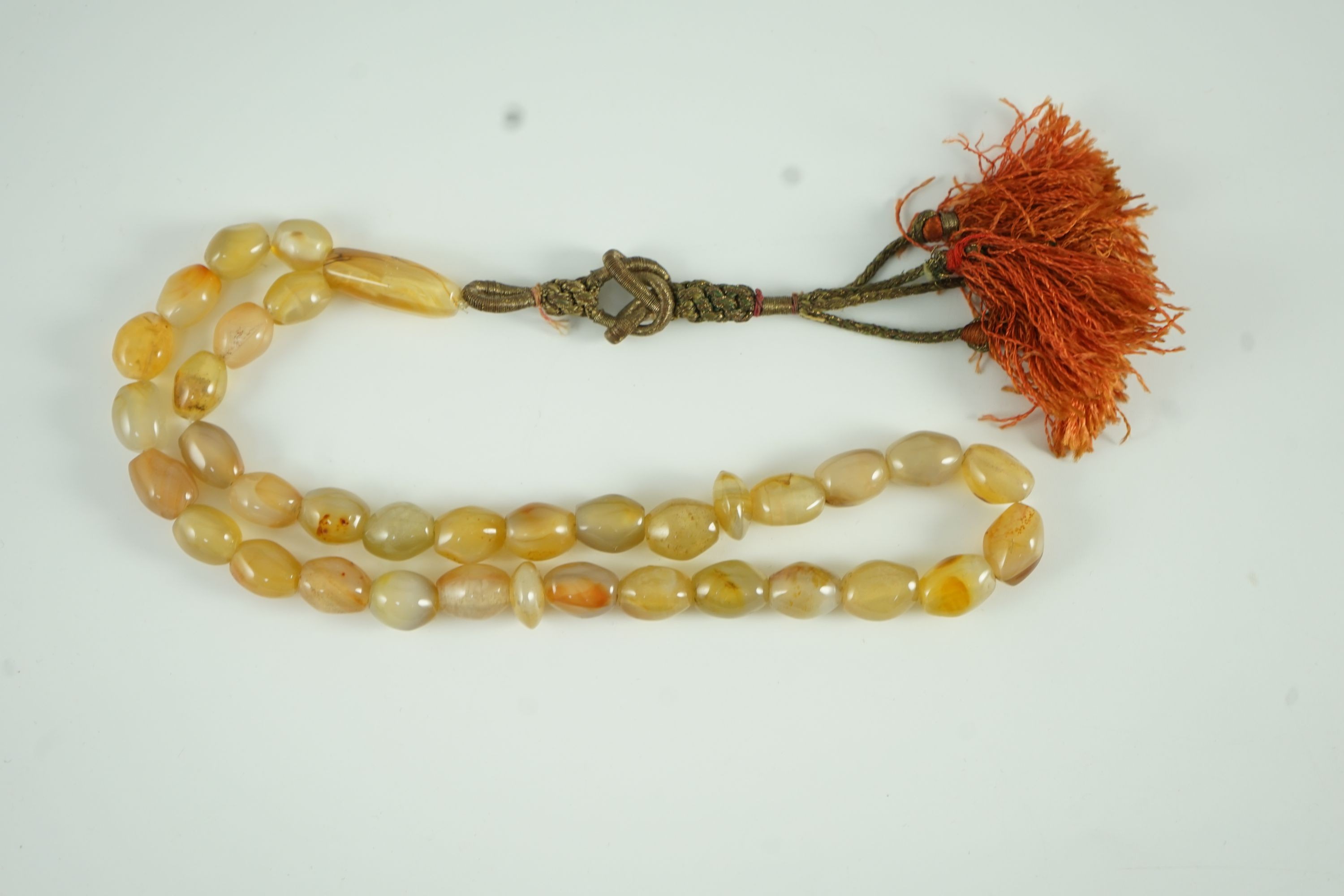 A Sino-Tibetan row of agate prayer beads, 19th century Total drop including tassel 36 cm